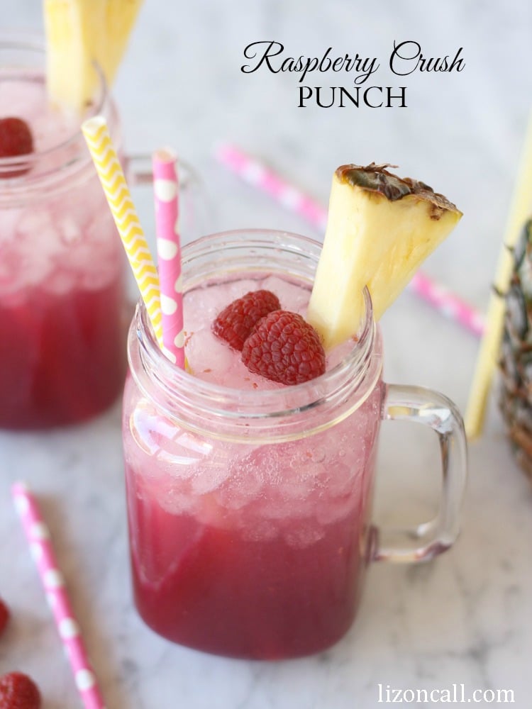 A festive glass of pink punch over crushed ice. Photo titled Raspberry Crush Punch - considered the best party punch recipe